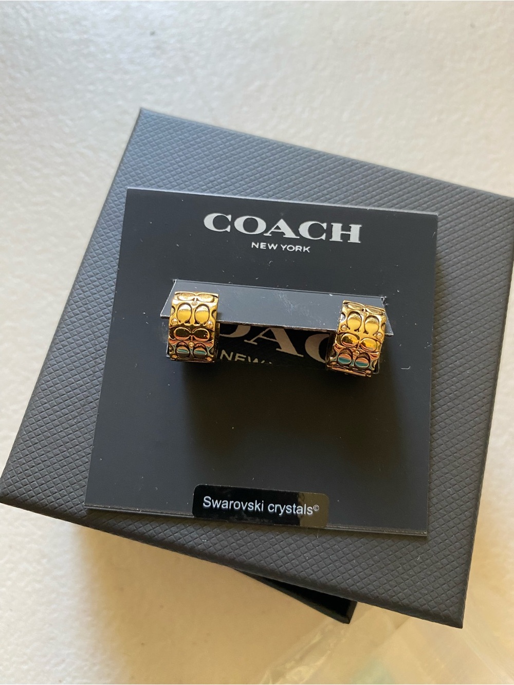 Coach gold signature quilted cut out huggie earrings.